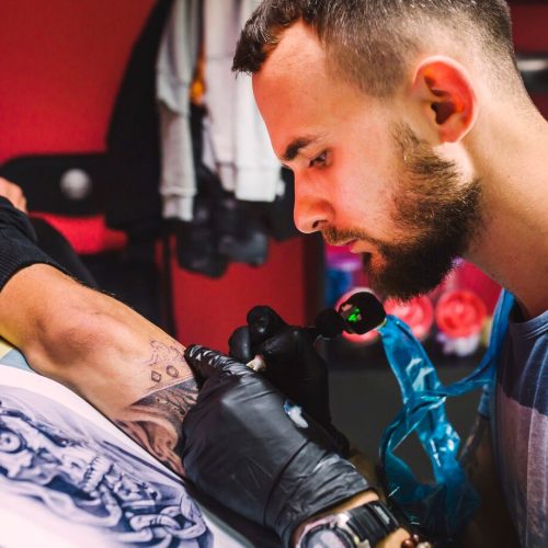 adult-man-working-with-tattoo-pen-arm_23-2147834089