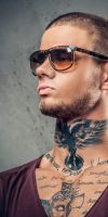 handsome-athletic-male-sunglasses-with-tattoos-his-arms-neck-posing-grey-artistic-background-studio_613910-15813