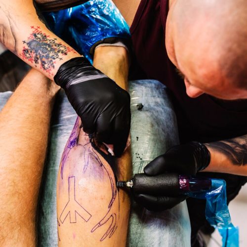 male-master-doing-tattoo-leg_23-2147834101