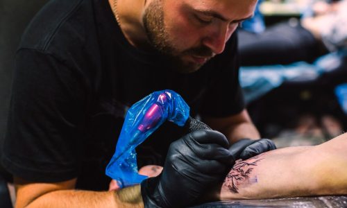 master-doing-tattoo-with-iron-salon_23-2147834114