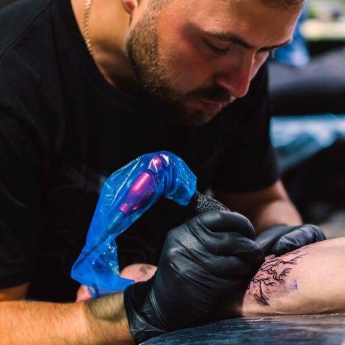 master-doing-tattoo-with-iron-salon_23-2147834114