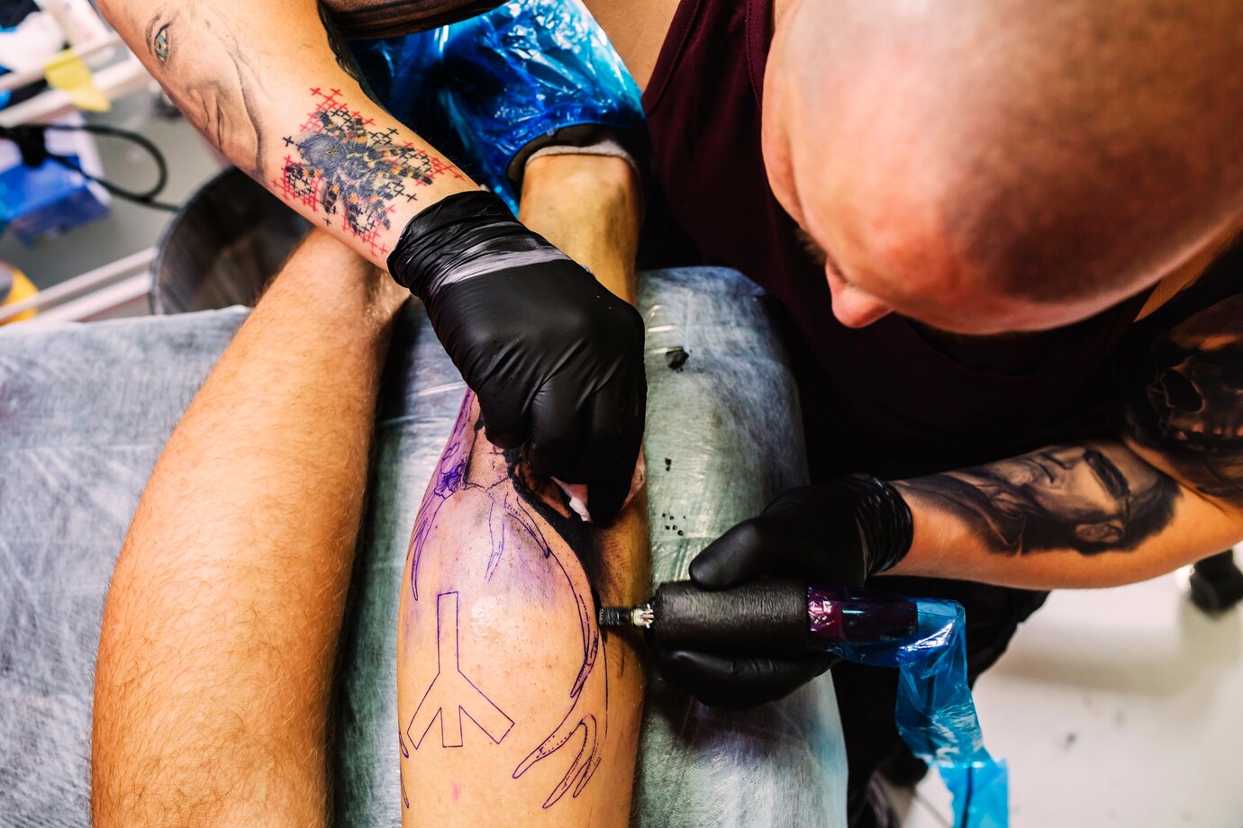 male-master-doing-tattoo-leg_23-2147834101